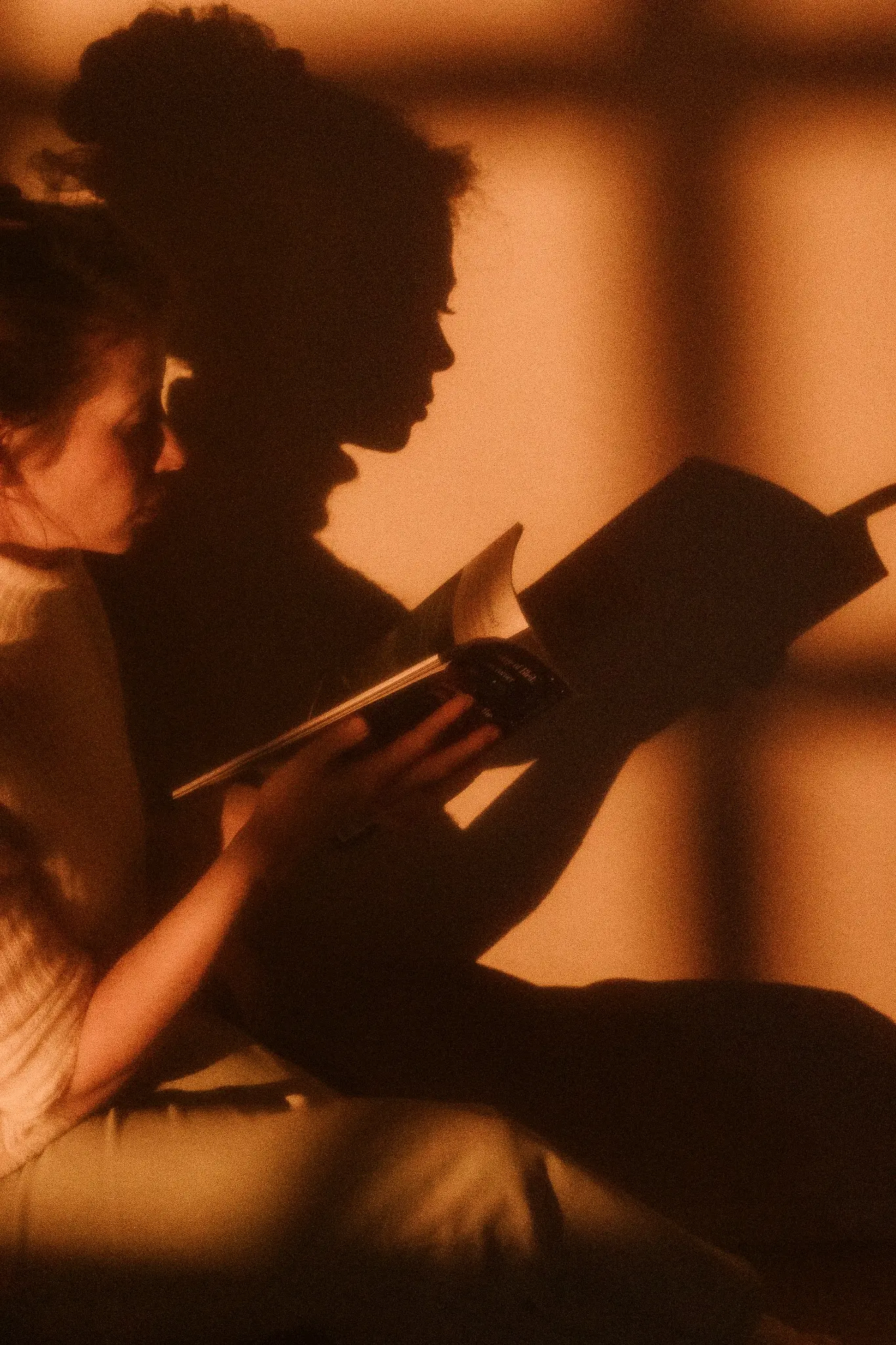 Joy reading with the warm silhouettes of children beside her